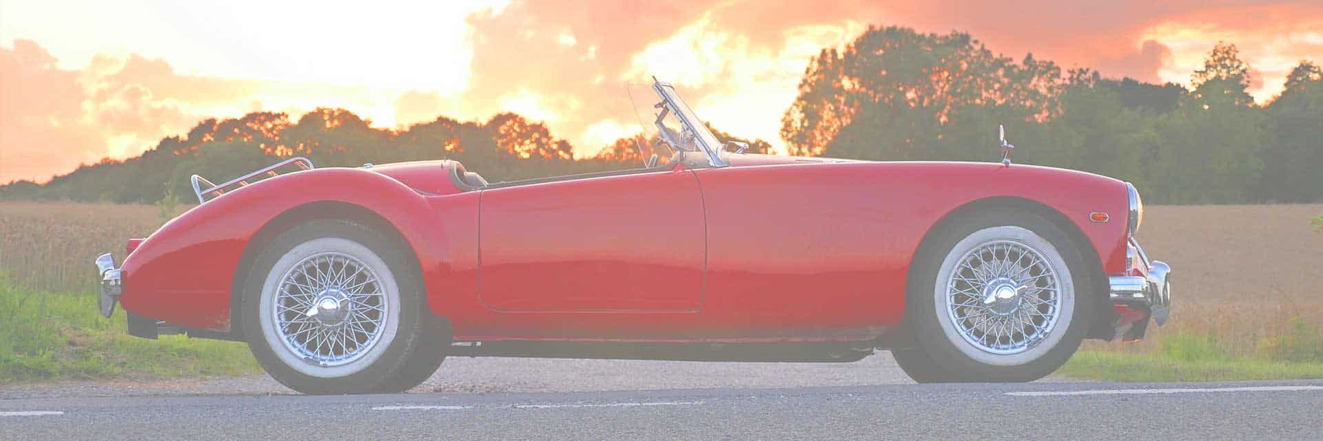 classic red convertible sports car at sunset