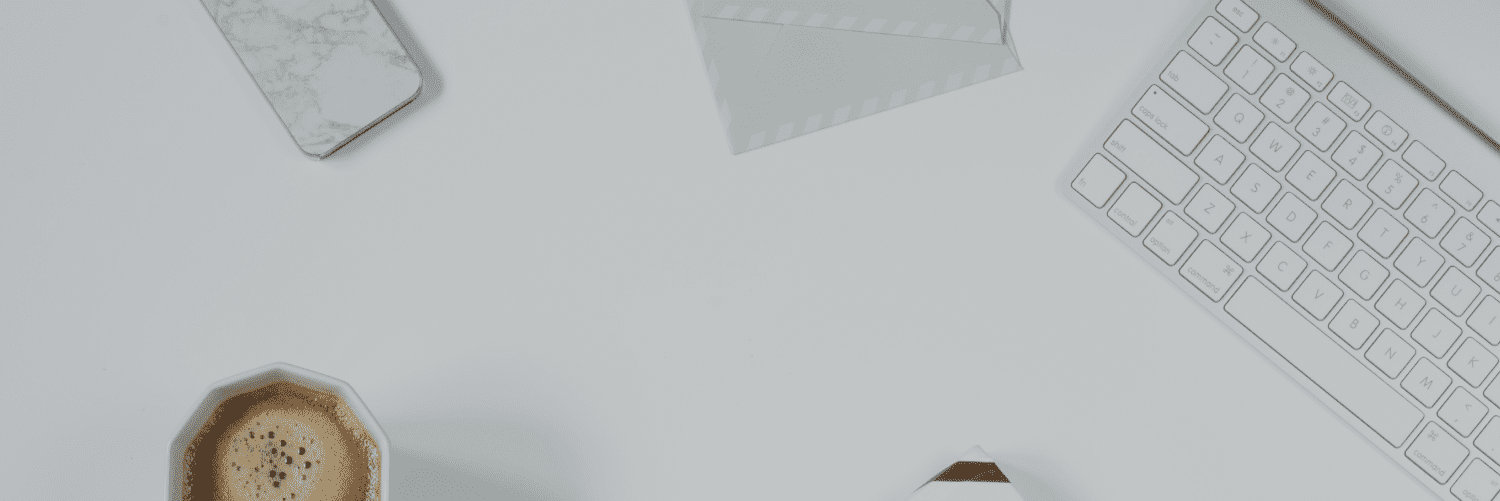 coffee cup on desk with white computer keyboard