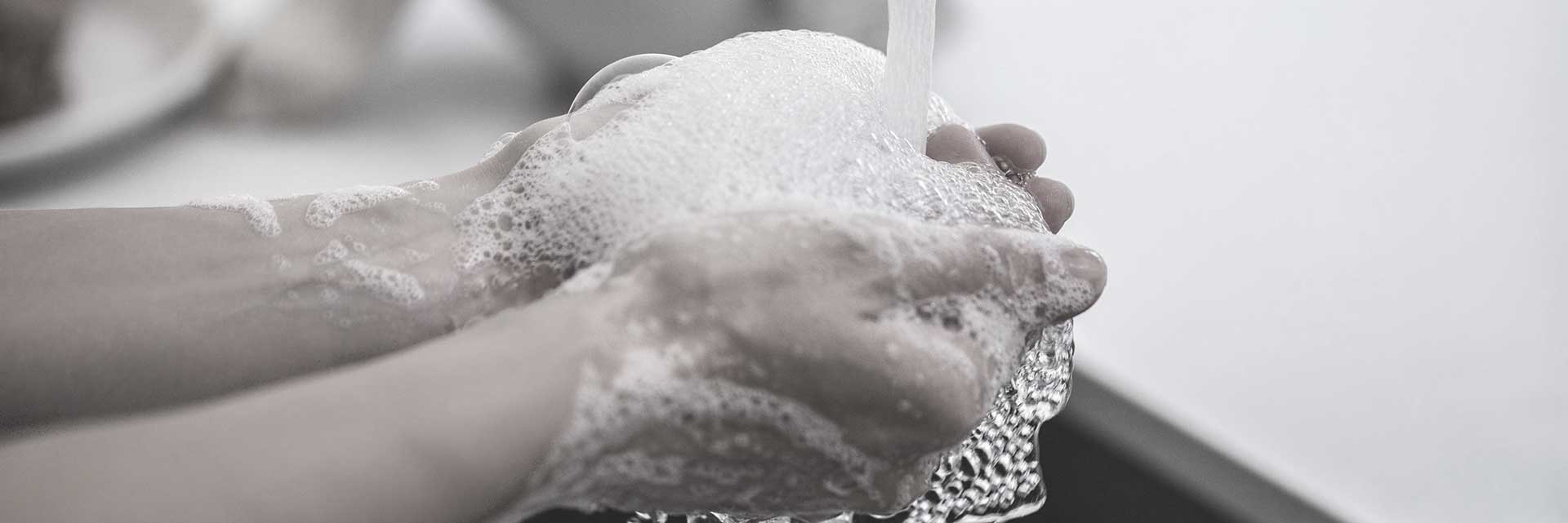 washing hands under faucet