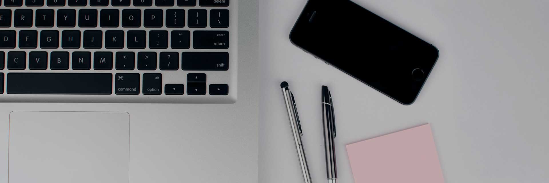 phone, pens, and laptop on desk