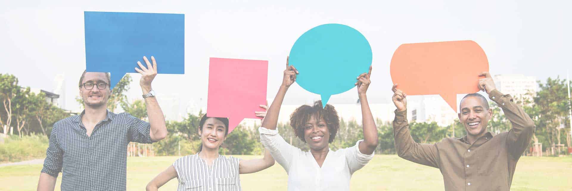people holding up colored talk bubbles