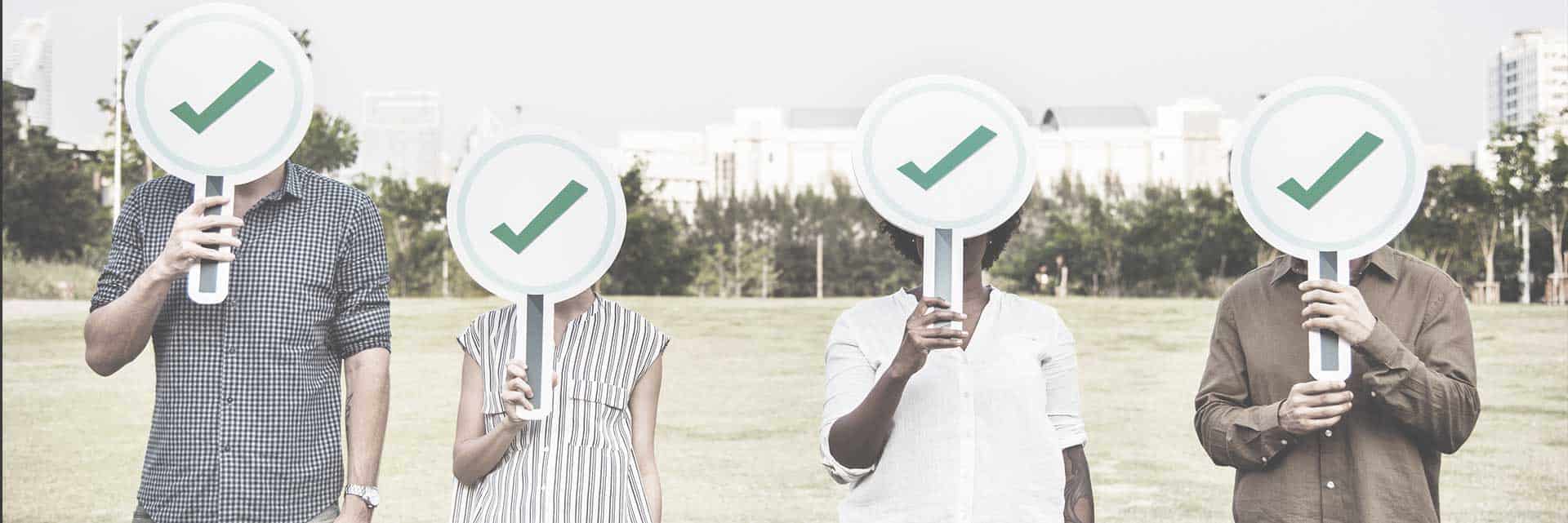 people holding up check mark signs