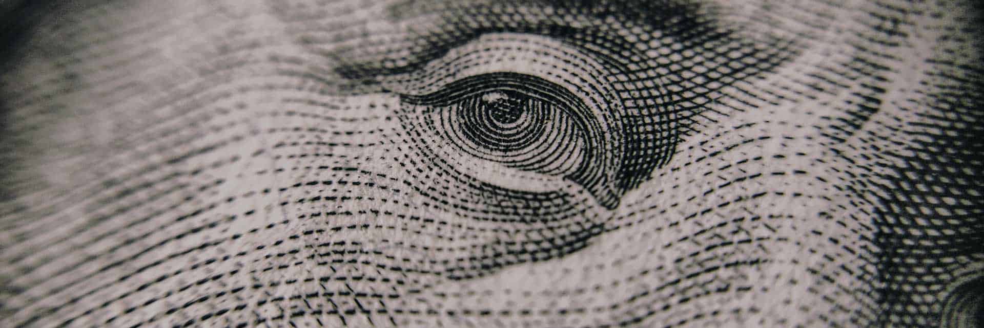 close up of benjamin franklin's eye from $100 bill