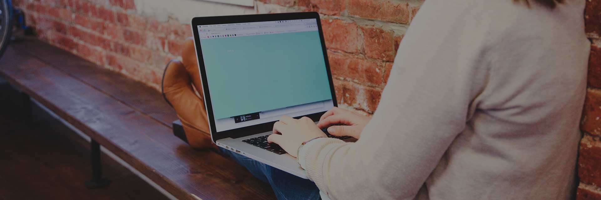 woman using a laptop on bench