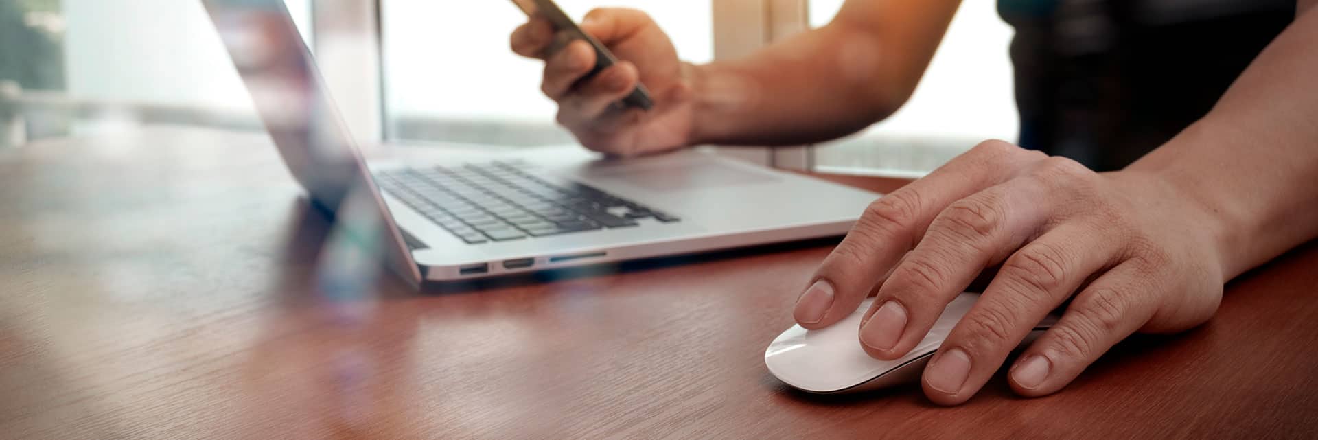 Hands using smartphone and laptop